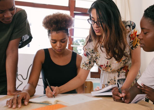 A group of people celebrating together, writing in their gratitude journals